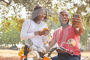 aafrican man and woman look at phone excitedly