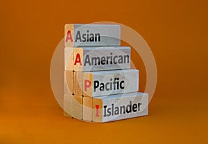 AAPI symbol. Abbreviation AAPI asian american pacific islander on wooden blocks. Beautiful orange background. Copy space. Business
