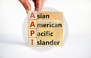 AAPI symbol. Abbreviation AAPI asian american pacific islander on wooden blocks. Beautiful white background. Businessman hand.