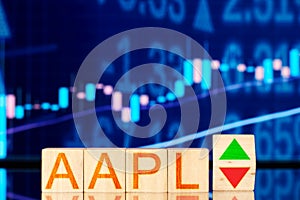 Aapl. wooden cubes with the inscription aapl and a cube symbolizing the rise and fall of the financial market