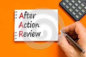 AAR After action review symbol. Concept words AAR After action review on beautiful white note. Beautiful orange background.