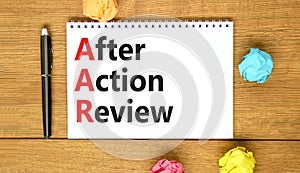 AAR After action review symbol. Concept words AAR After action review on beautiful white note. Beautiful wooden table wooden
