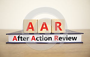 AAR After action review symbol. Concept words AAR After action review on beautiful wooden blocks and book. Beautiful white