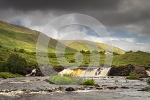 Aasleagh Falls on Erriff River with a single house under Letterass Mountains, Ireland