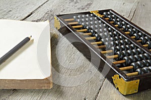 Abacus with book on wooden background