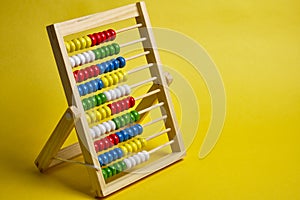 Abacus at yellow background. Shopping, personal finances, money spendings concept