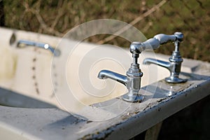 Abadonded ceramic bathtub showing detail of the high quality taps.