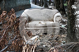 Abadoned couch with trash in garden in Utila, Honduras, Central America