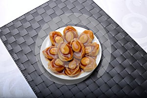 Abalone servings in a fine dining setting on black table mat photo