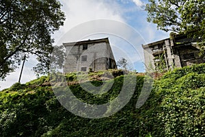 Abandoned 1960s` apartment buildings of factory on weedy hill