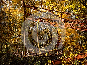 Abandoned amusement park in ghost town Pripyat. Overgrown trees and collapsing buildings in Pripyat, Chernobyl exclusion zone.