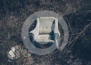 Abandoned armchair as garbage disposed in nature