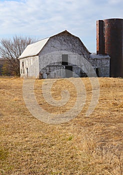 Abandoned Barn and Silo Stand Alone in Winter