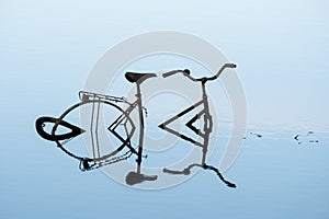 Abandoned bicycle standing in a river
