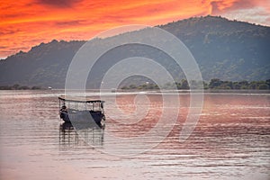 abandoned boat adrift marooned in the middle of water of lake pichola surrounded by aravalli hills in tourist city of