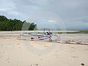 The abandoned boat perahu nelayan di pinggir pantai photo