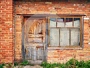 abandoned brick building, shabby old door closed, window curtained with faded fabric