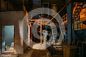 Abandoned brick and paving slabs factory at night. Old rusty machinery