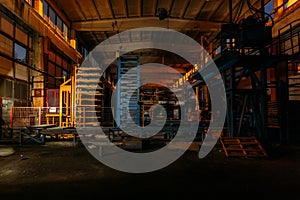 Abandoned brick and paving slabs factory at night. Old rusty machinery