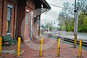 Abandoned brick train depot with tracks and graffiti