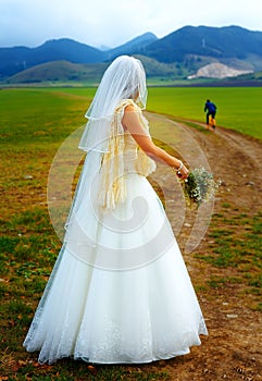 Abandoned bride and groom running away on a bike - funny wedding concept.