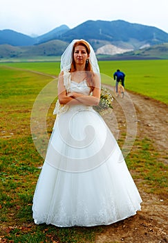 Abandoned bride and groom running away on a bike - funny wedding concept.