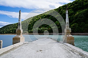 Abandoned bridge going underwater near water dam