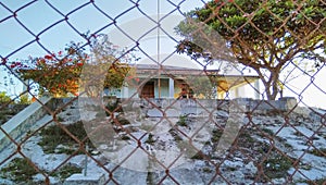 Abandoned building behind the wire fence in Venilale, Timor-Leste. photo