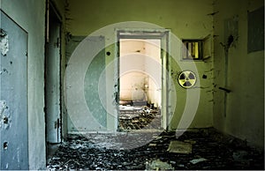 Abandoned building with broken glass and grunge walls because of nuclear accident. Radioative warning sign on the wall. Chernobyl