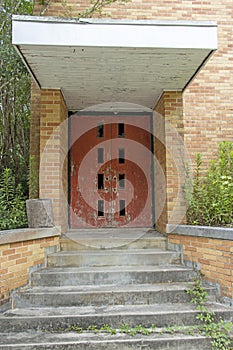 Abandoned building double doors with over growth