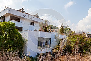 Abandoned building exterior view of Hotel in the Turkish village of kemer with broken windows and overgrown plants