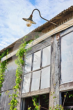 Abandoned building, glass windows, faded gray barn wood walls, metal structure, light sconce