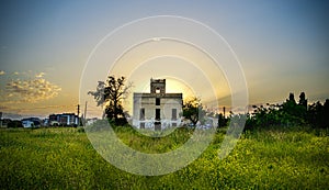 Abandoned building in a grass field during sunset in Reus, Catalonia, Spain photo