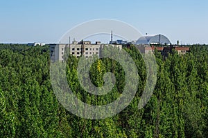 Abandoned buildings and sarcophagus above the reactor in ghost town Pripyat Chornobyl Zone photo