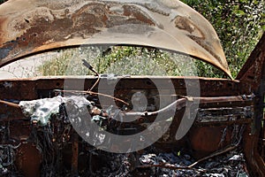 Abandoned and burned car in the middle of the forest