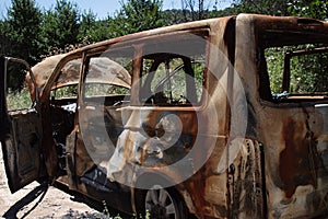 Abandoned and burned car in the middle of the forest