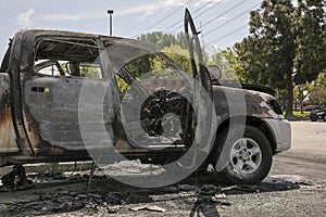 Abandoned burned car in a parking lot.  Close up of melted interior