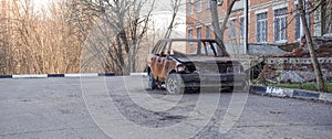 Abandoned burned passenger car near the apartment building. Russia