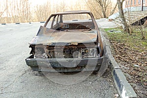 Abandoned burned passenger car near the apartment building. Russia