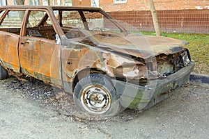 Abandoned burned passenger car near the apartment building. Russia