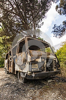 Abandoned burning van next to a forest