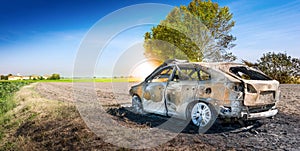 Abandoned burnt car at isolated field