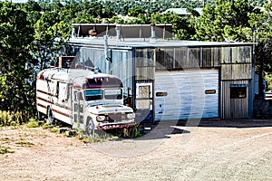 Abandoned Bus by a locked up shed in the Southwest