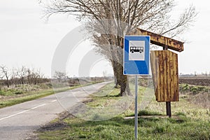 Abandoned bus stop Yugoslav design, in front of a neglected countryside landscape and a damaged road in Serbia, in a rural area photo