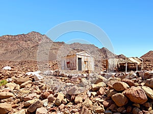 Abandoned cabins in a desert area of the Sinai Peninsula. Destroyed Bedouin hut between rocks. Constructions and Architecture of