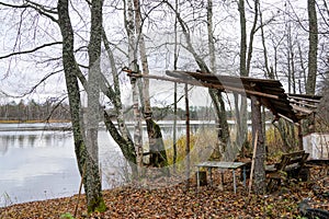 abandoned camp fishermen hunters on the shore of the lake in the autumn forest