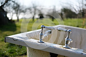 Abandoned ceramic bathtub showing detail of the high quality taps.