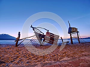 Abandoned children playground at frozen lake. Wooden ship