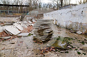 Abandoned children`s camp. An old abandoned and ruined pool. Old pool tiles and steps.
