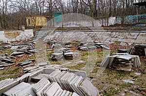 Abandoned children`s camp. An old abandoned and ruined pool. Old pool tiles and steps.